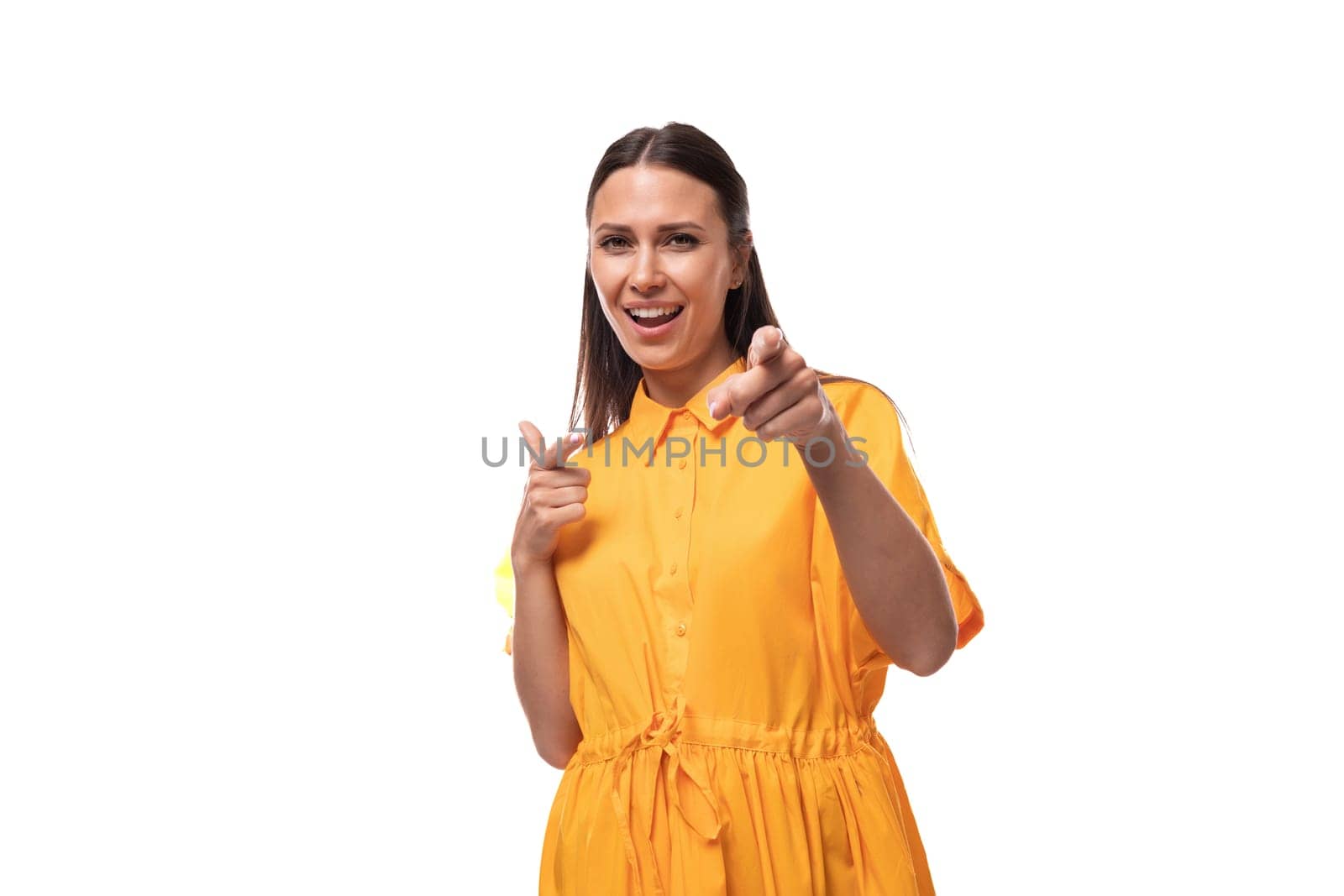 young friendly brunette woman dressed in a summer yellow dress attracts attention.