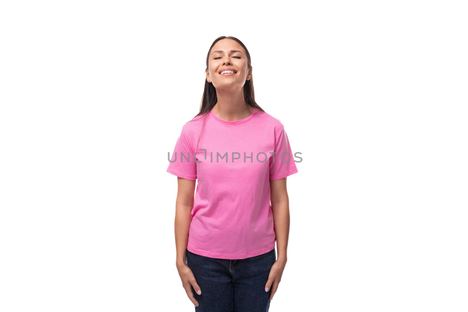 young happy brunette woman in pink basic t-shirt on white background with copy space.