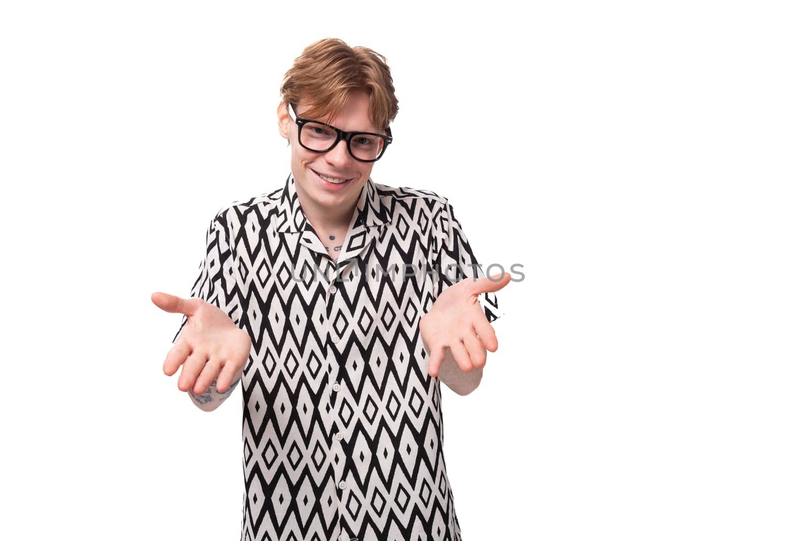 young laughing caucasian ginger man with a tattoo on his arms is dressed in a black and white short sleeve shirt by TRMK