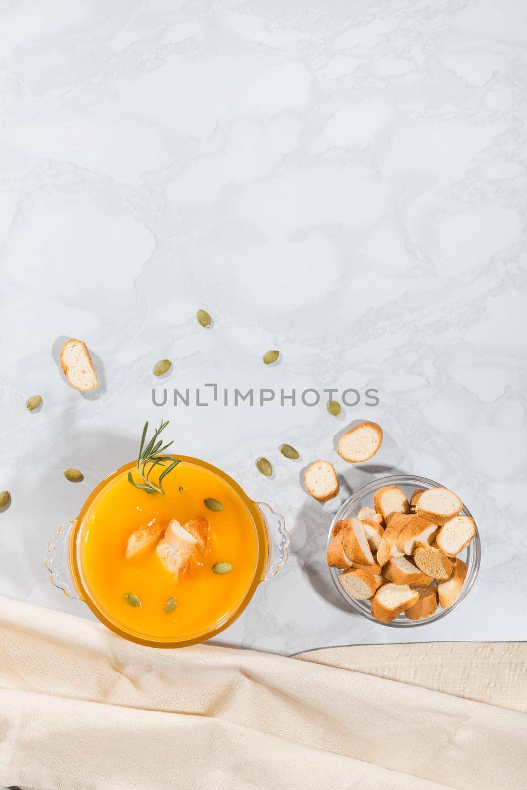 Pumpkin cream soup with crackers and seeds, top view, with copy space. Vegetarian lunch