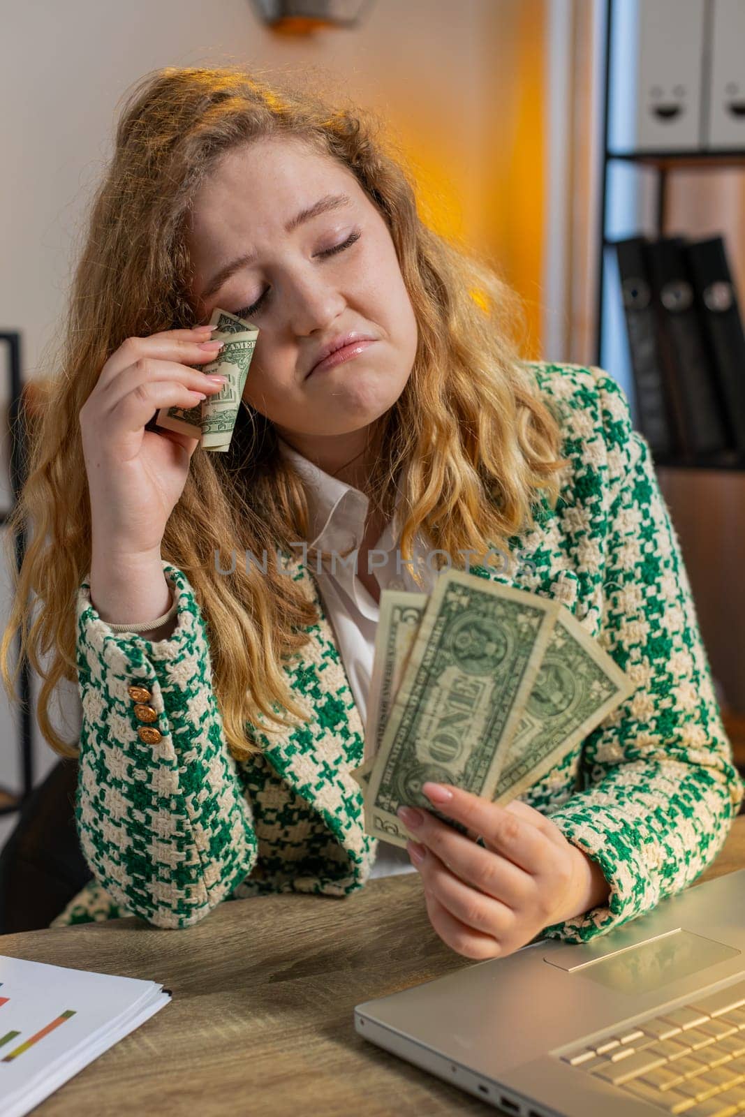 Caucasian young woman freelancer counting cash insufficient amount of money. Financial crisis. Bankruptcy. Poverty and destitution. Female girl businesswoman with laptop sitting at home office desk