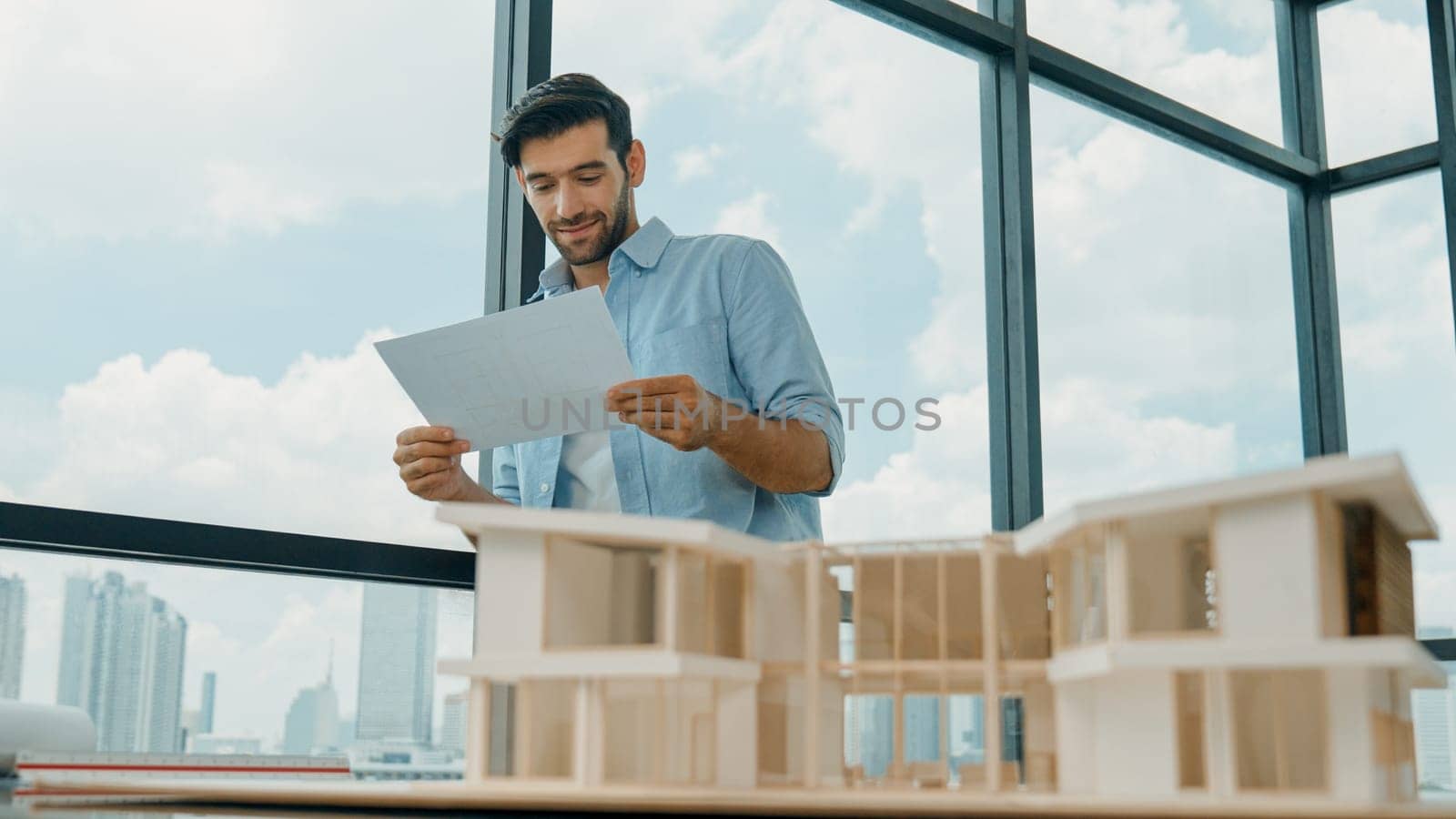 Architect engineer reading blueprint while inspect house model. Tracery by biancoblue