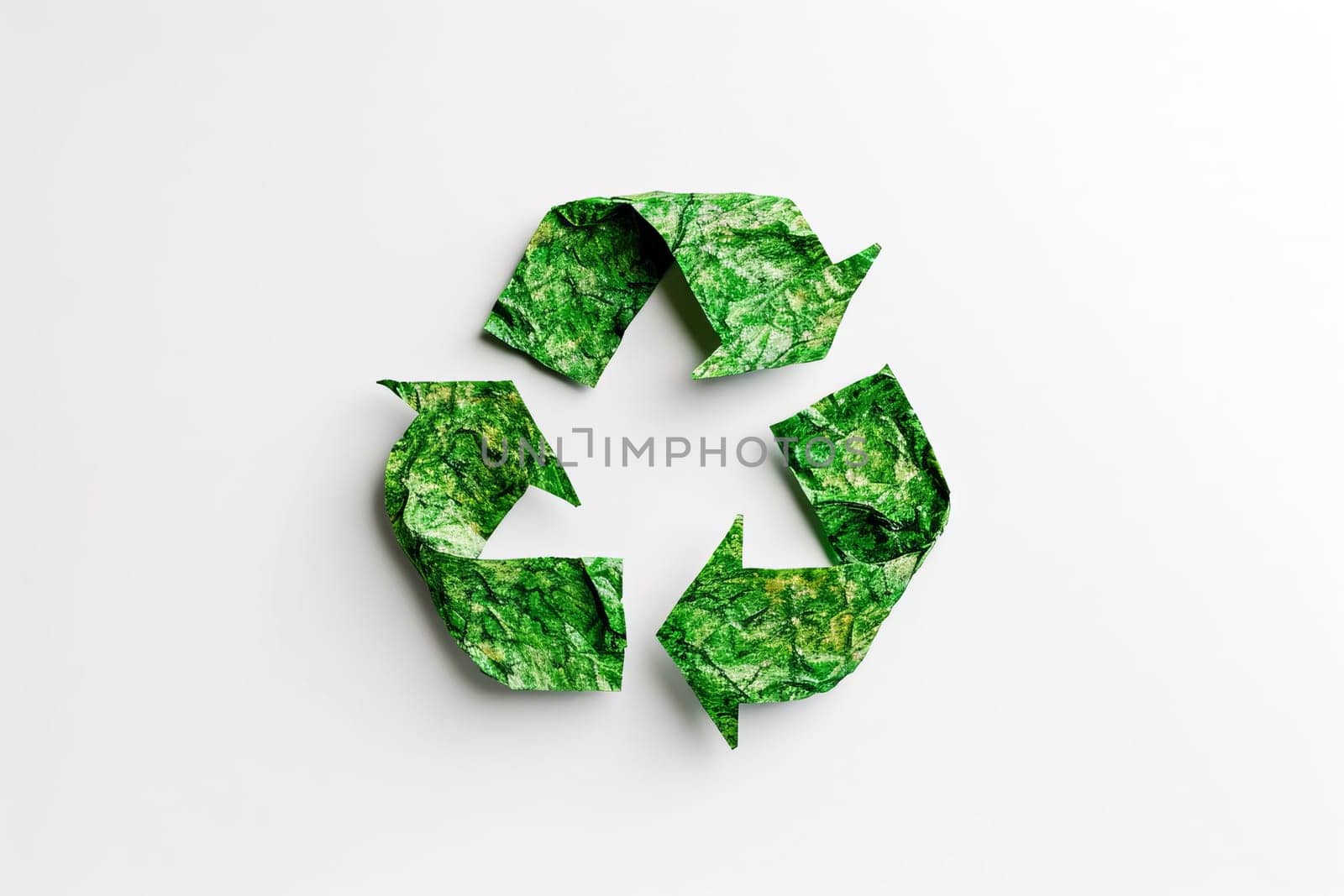 Recycling symbol made of crumpled green paper on a white background. Environmental protection concept.