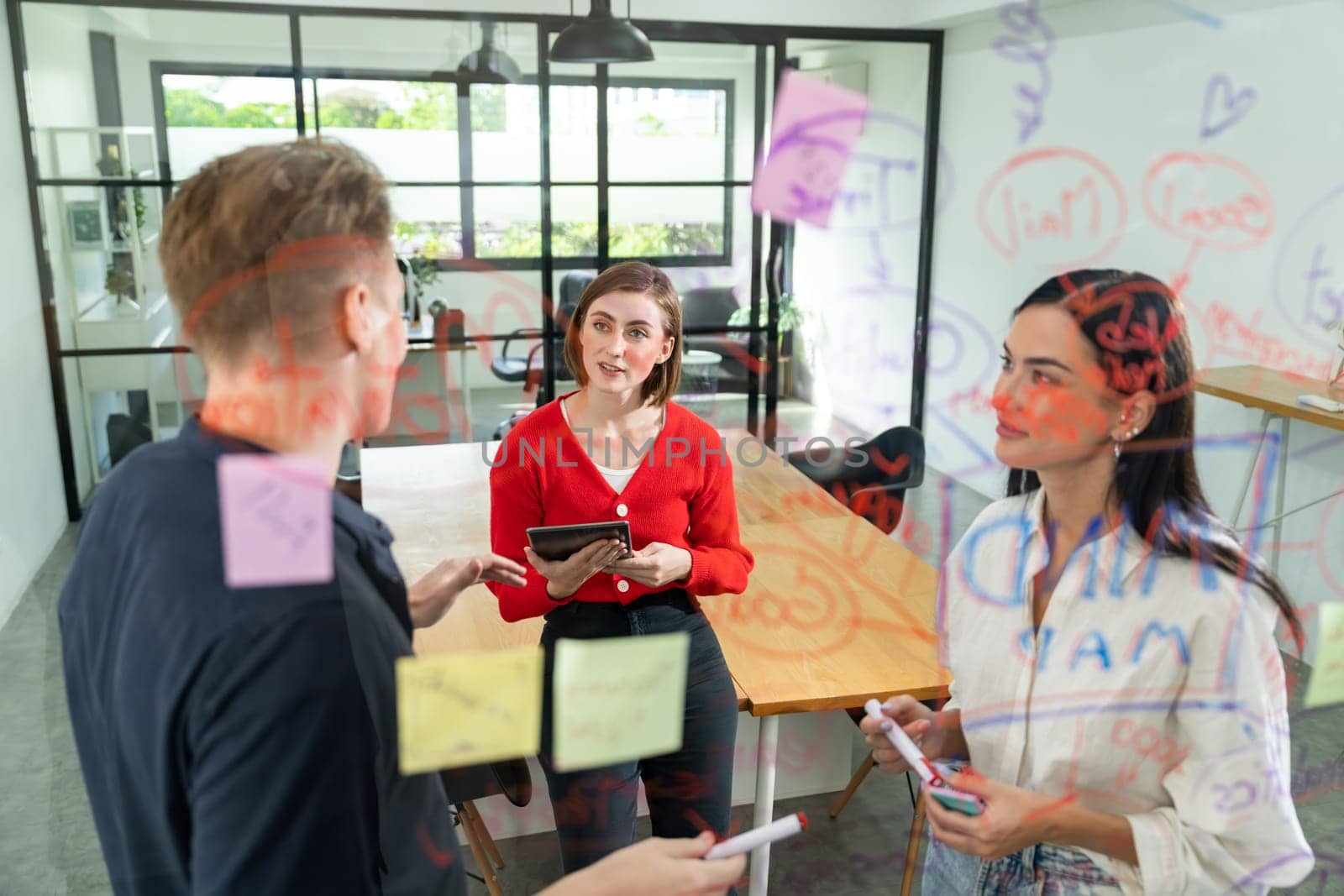 Creative business team brainstorming discussing and sharing marketing idea about start up project by using mind map colorful sticky note at glass board meeting room. Working together. Immaculate.