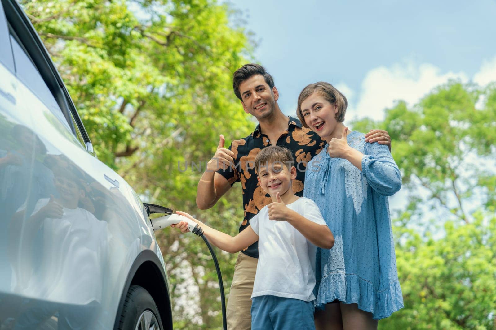 Family road trip vacation with electric vehicle, lovely family recharge EV car with green and clean energy. Natural and eco friendly car travel for sustainable environment. Perpetual