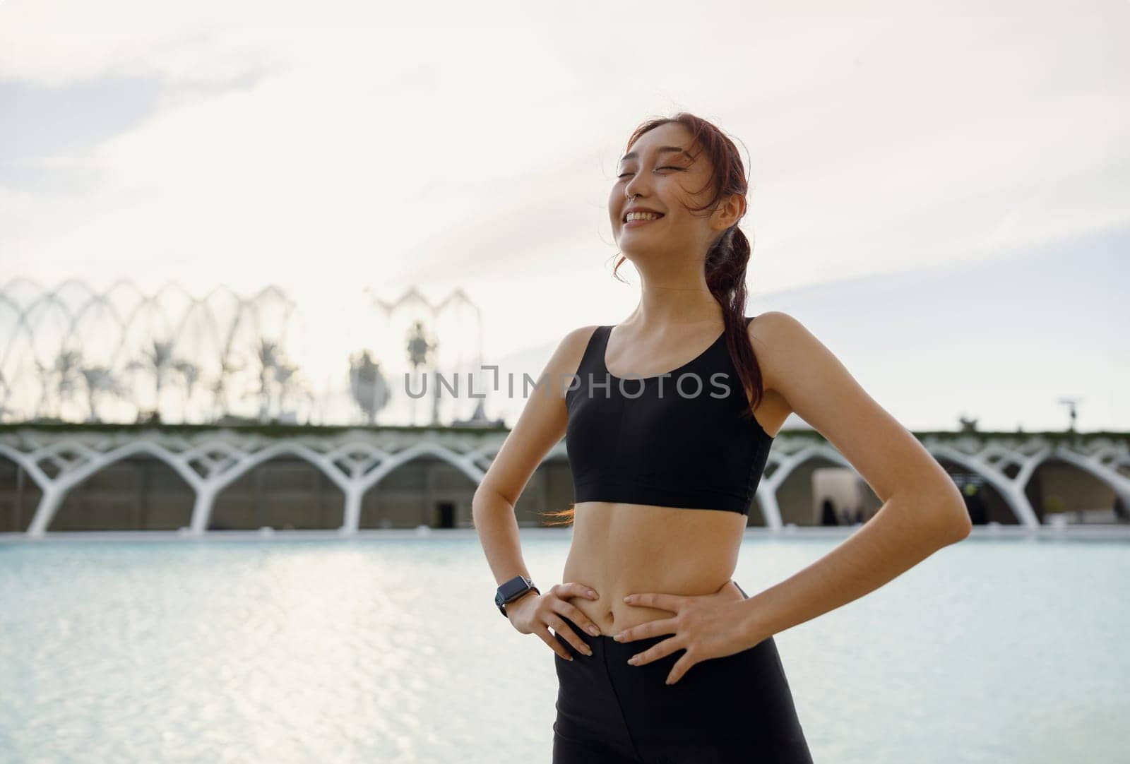 Female athlete in sportswear have a rest after morning jogging outside and looks away