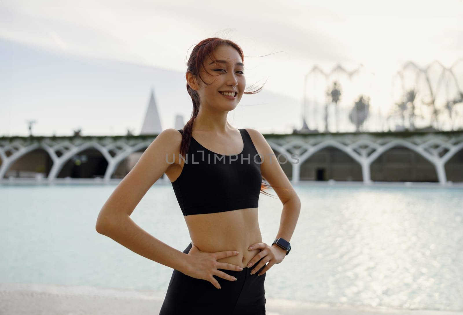 Female athlete in sportswear have a rest after morning jogging outside and looks camera by Yaroslav_astakhov