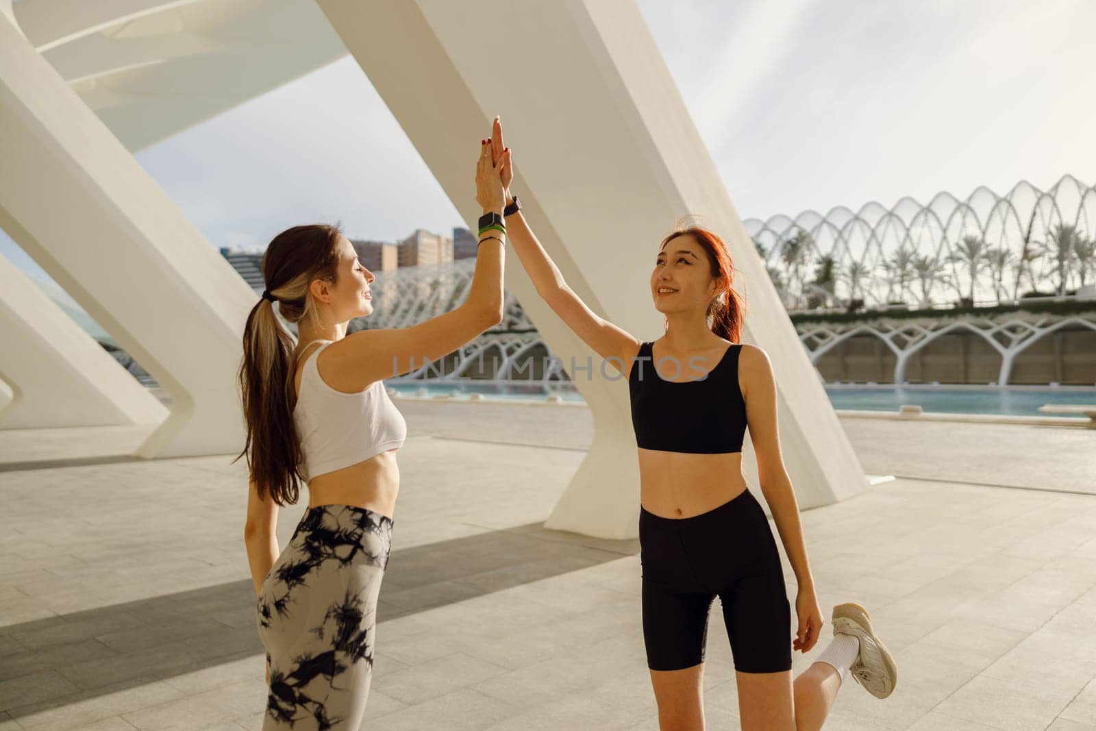 Sporty women greeting together outdoor doing gesture of shake hand after exercising by Yaroslav_astakhov