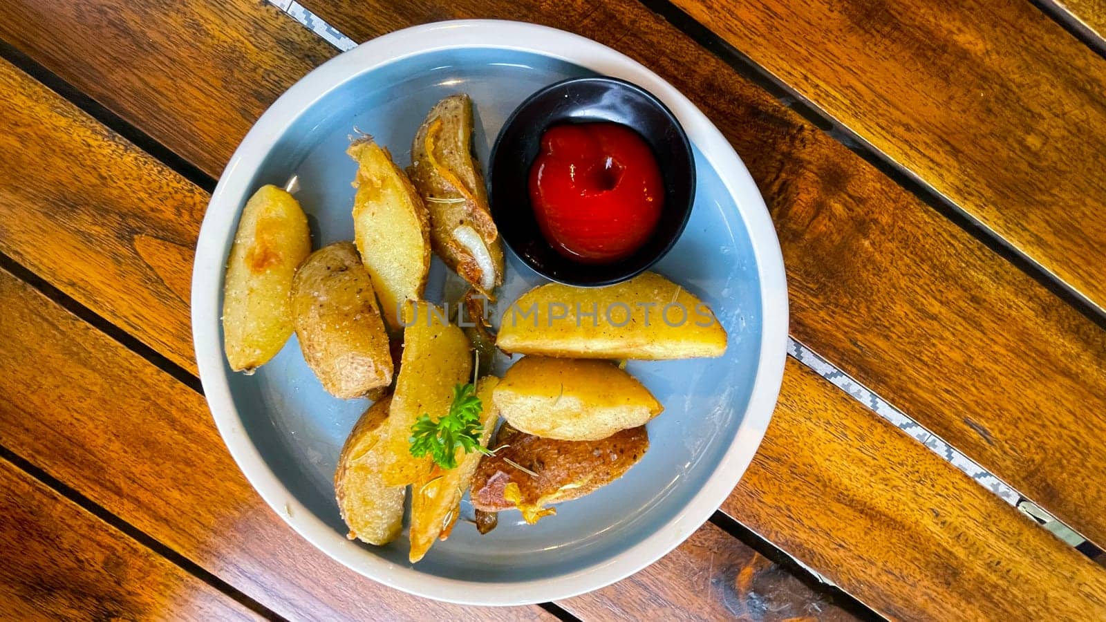 Top View Baked potato wedges with shredded onion and herbs and tomato sauce platted homemade organic vegetable vegan vegetarian potato wedges snack food meal