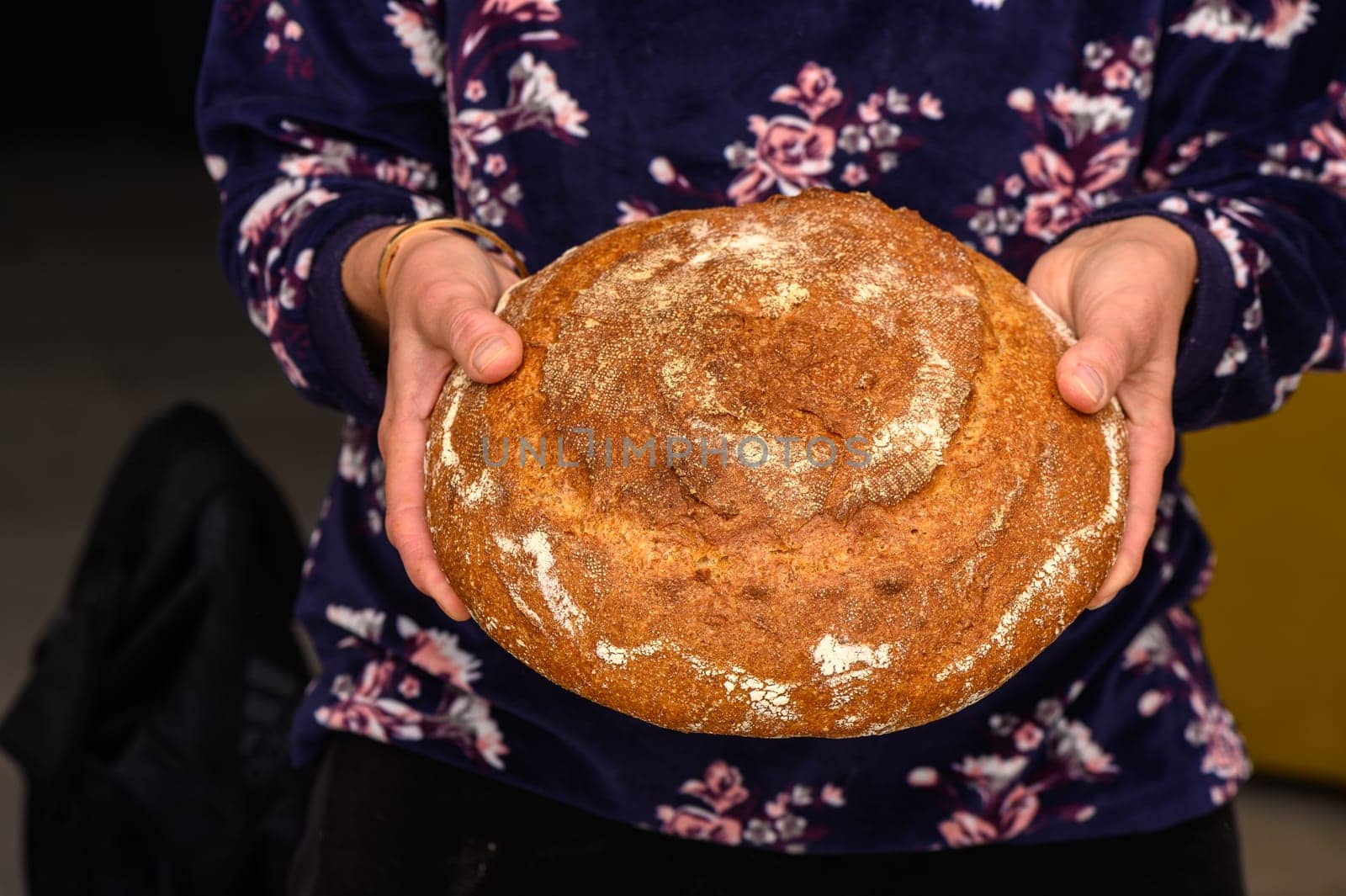 appetizing homemade whole grain bread in the hands of a woman