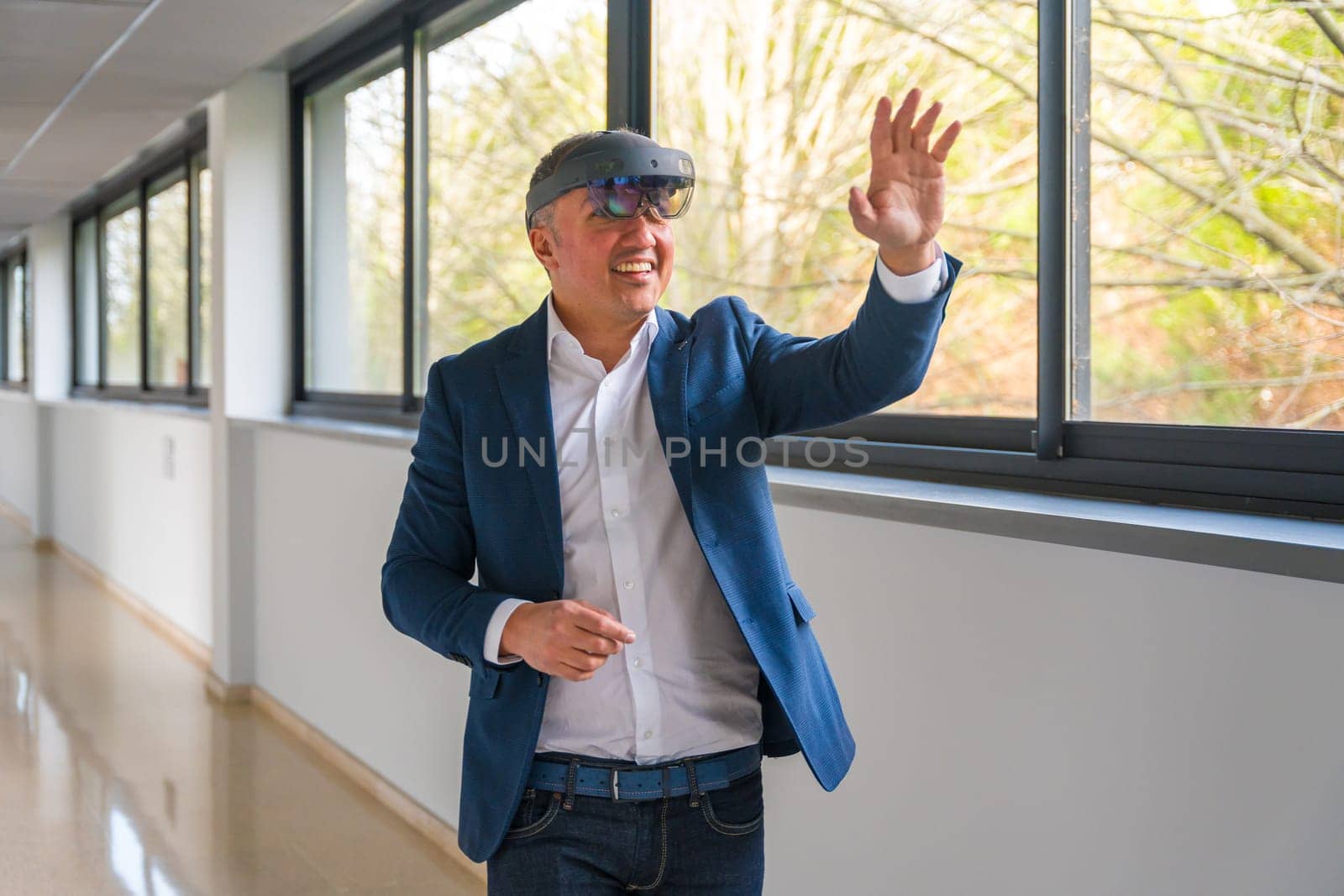 Happy casual mature businessman using Virtual reality simulator in the corridor of a building