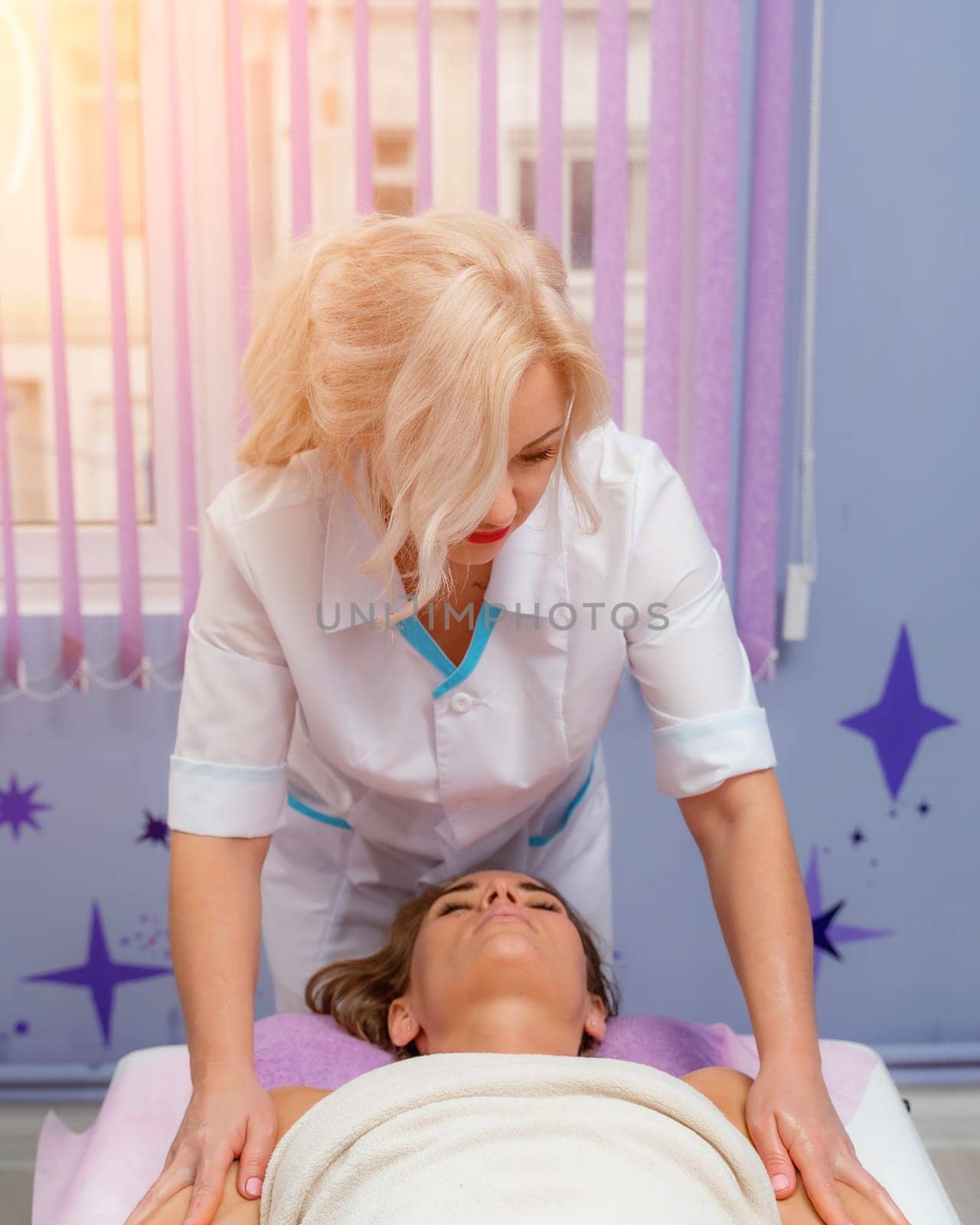 Masseur woman massages her shoulders. Woman getting a massage at the spa.