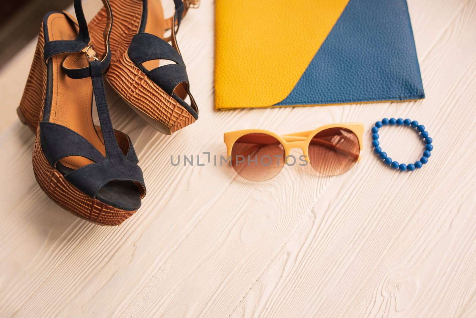 Sunglasses bijouterie jewelry bracelets clutch bag wedges shoes. Summer background mockup. top view above white wooden background Summer fashion accessories beach. Women summer design Vacation concept