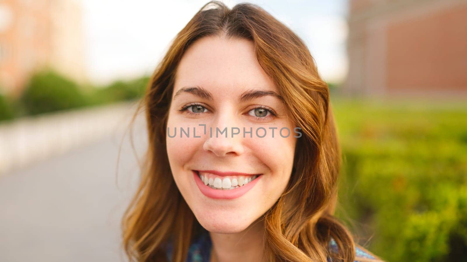 Close up view of a beauty woman with blue eyes looking to the camera and smiling