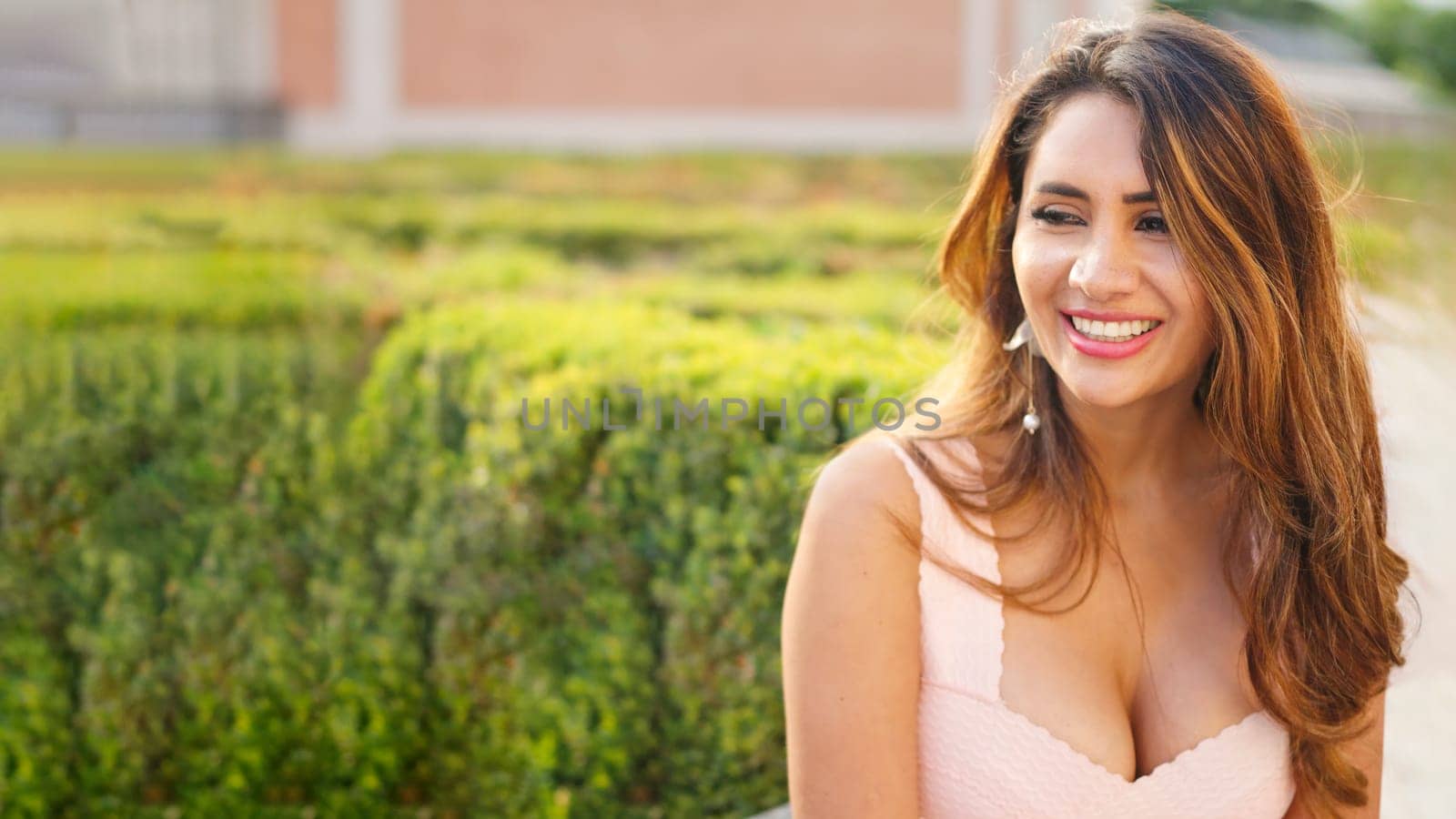 Pretty Hispanic girl smiling on the street looking at copy space on a summer day