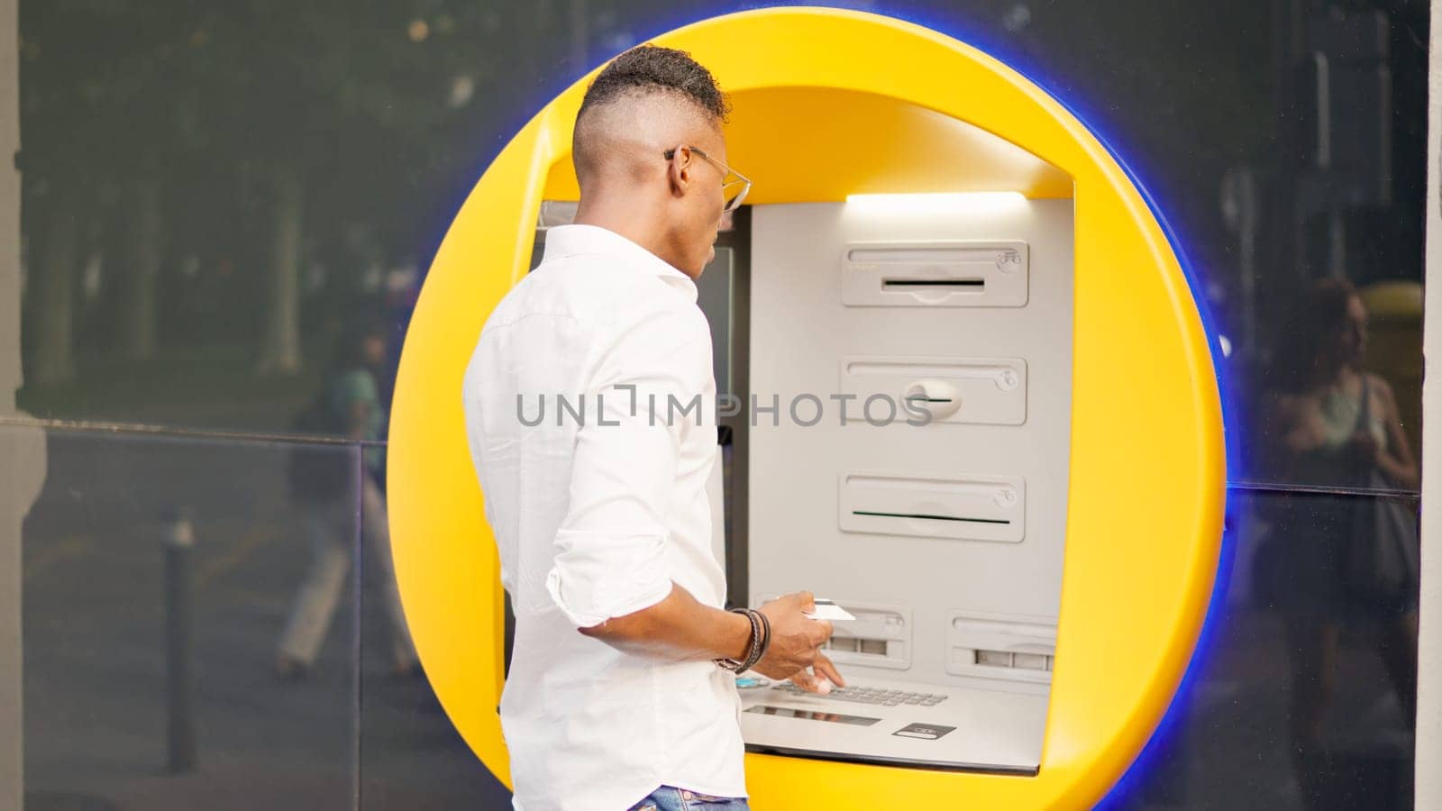 African man withdrawing money from the ATM in the street