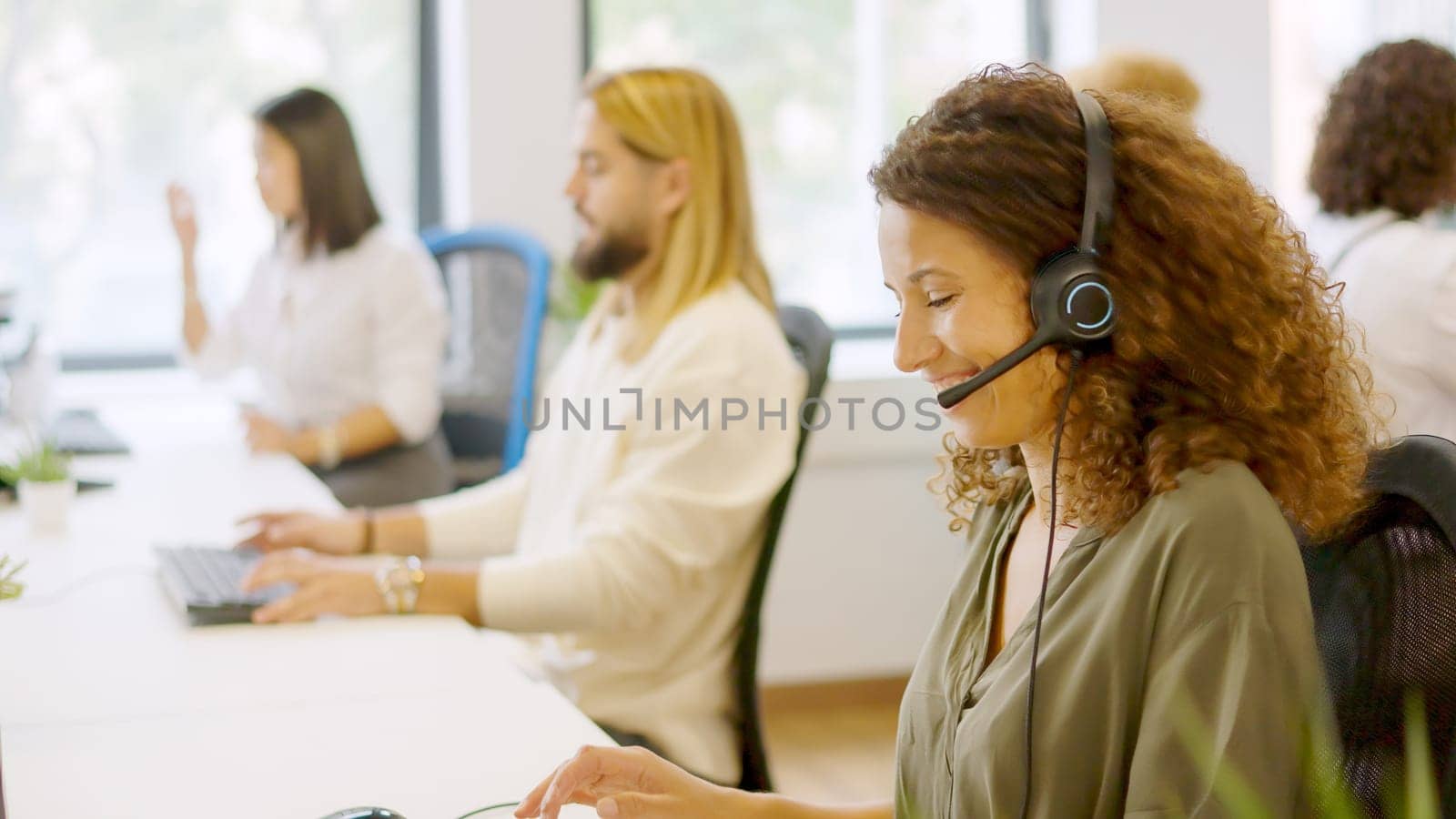 Female telephone operator smiling at camera sitting in the office