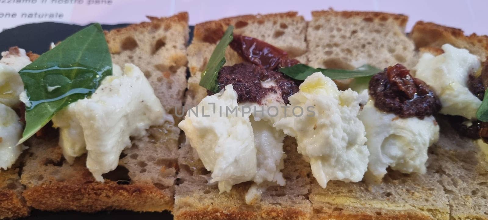 Appetizing close-up of a rustic open sandwich with creamy cheese and sundried tomatoes on grain bread