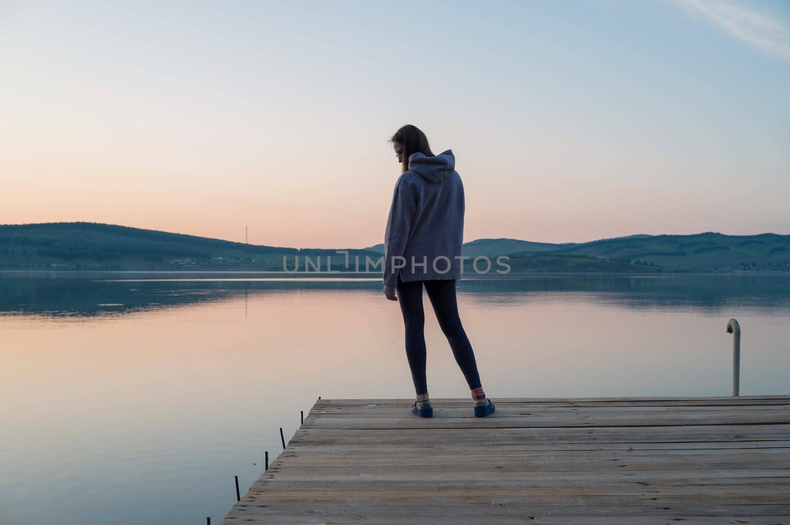 Woman on the pier at lake, closeup portrait, summer sunset