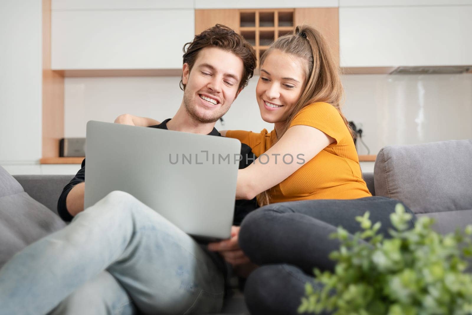 Couple using fast home internet with laptop. Woman and man on sofa in living room