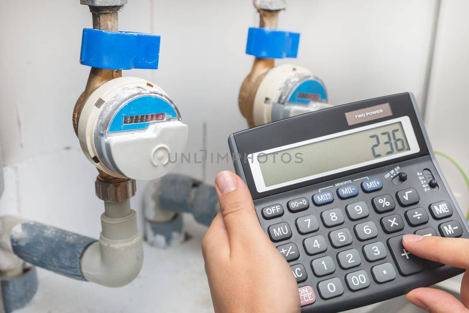 Water meter, concept of rising water prices, man with calculator