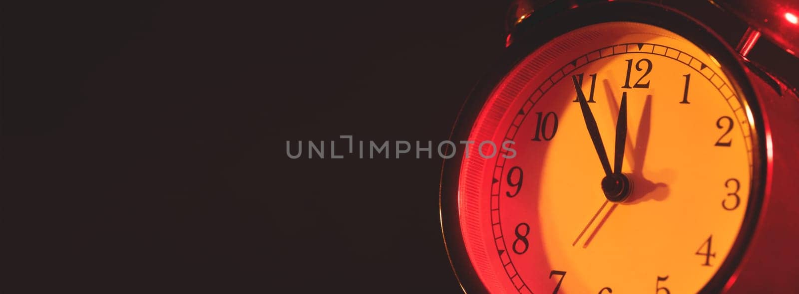 Five minutes to midnight. Changing the clocks, time adjustment, daylight savings or new year concept on retro analog clock, wide copy space background for internet banner