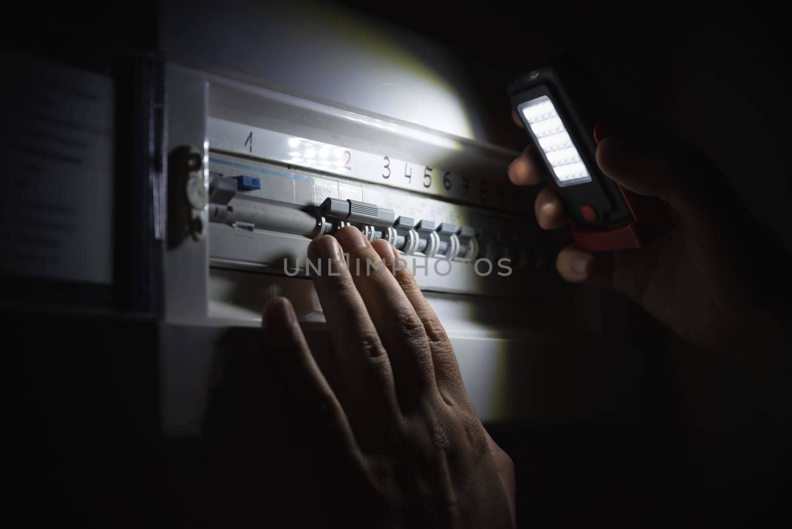 Investigate a home fuse box during a power outage. Blackout concept