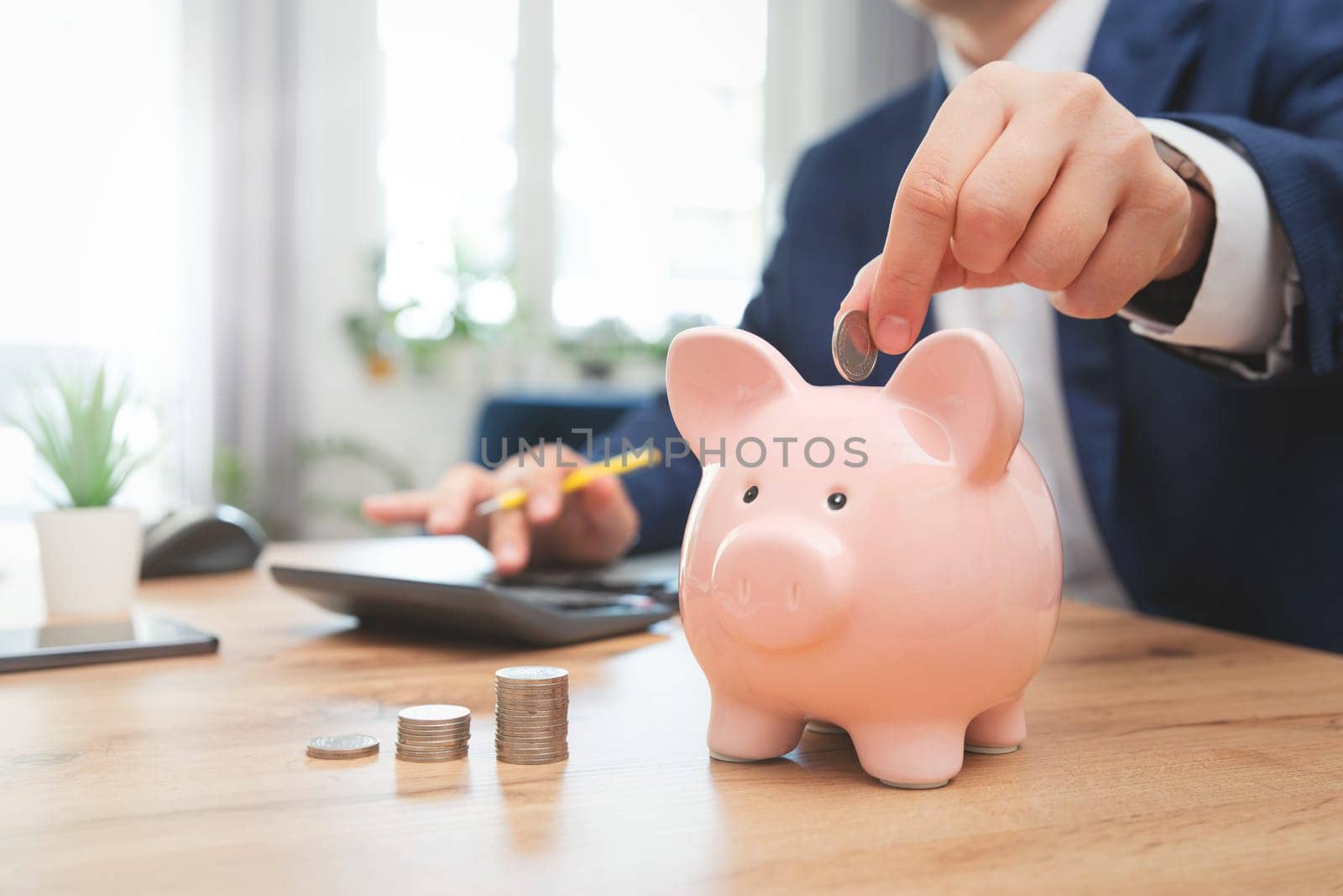 Putting a coin in a piggy bank. Savings, finances, economy and home budget