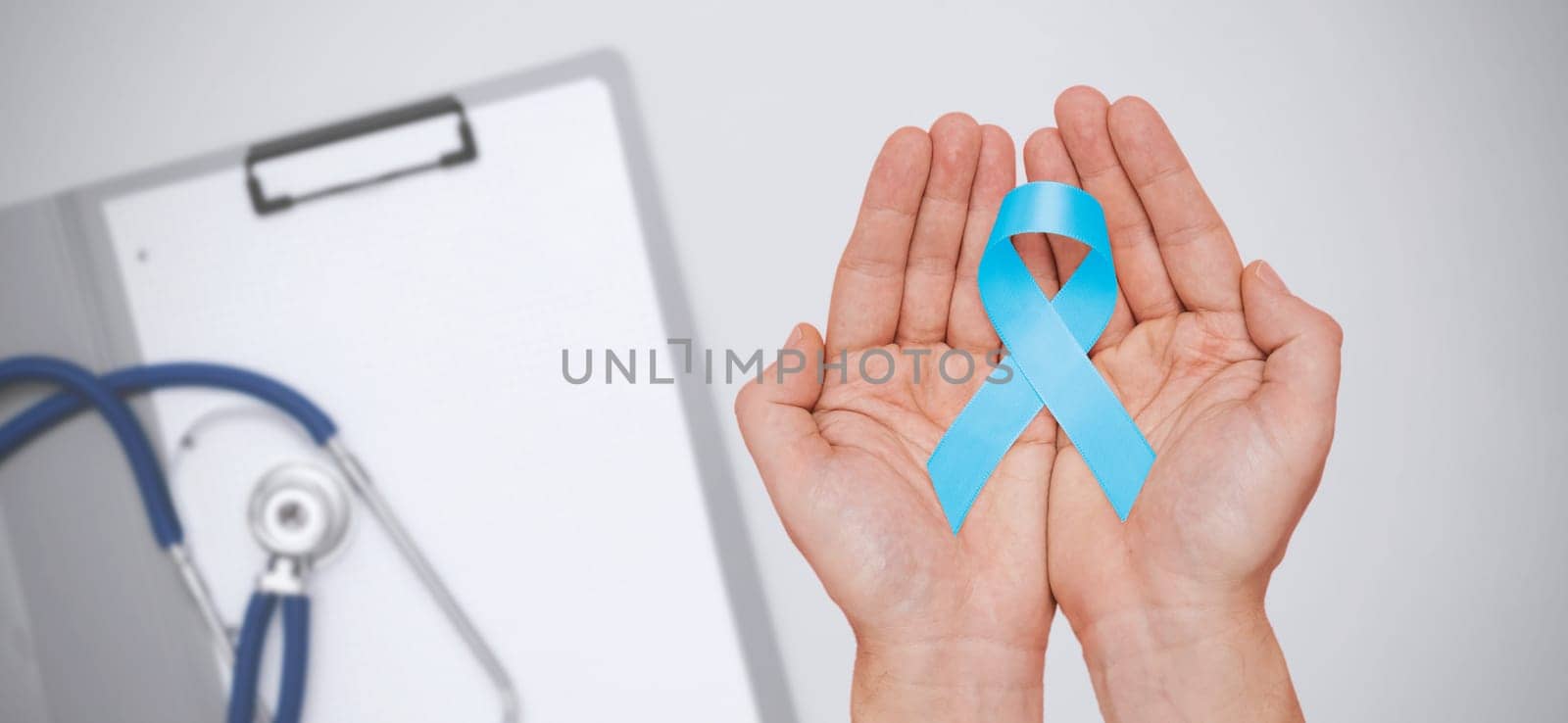Hand holding blue prostate cancer awareness ribbon by simpson33