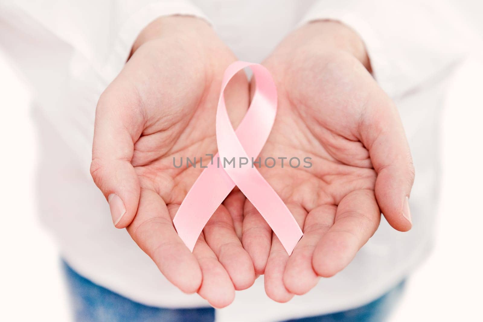 Hand holding pink breast cancer awareness ribbon by simpson33
