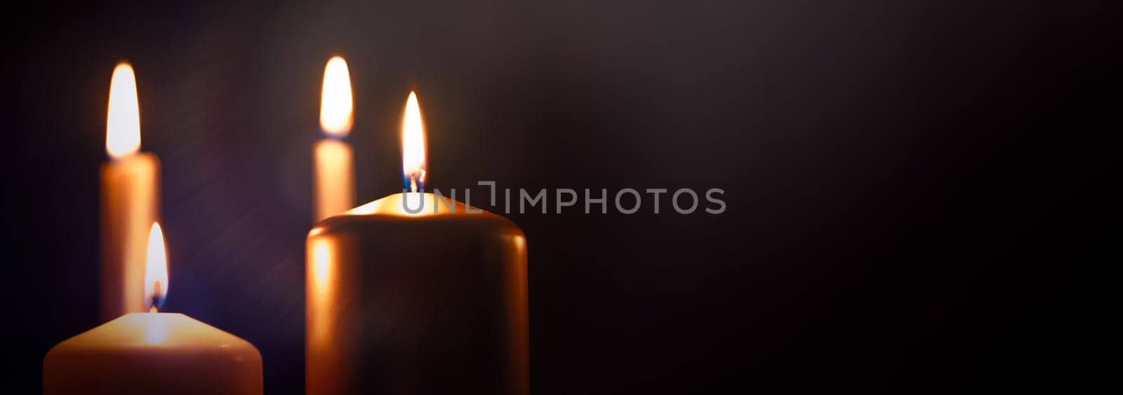 Funeral symbol with burning candle in darkness. Copy space.