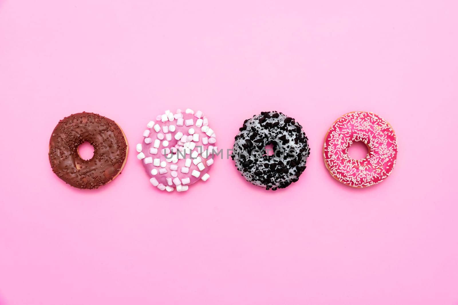 Delicious donut on color background. Mix of multicolored doughnuts, top view