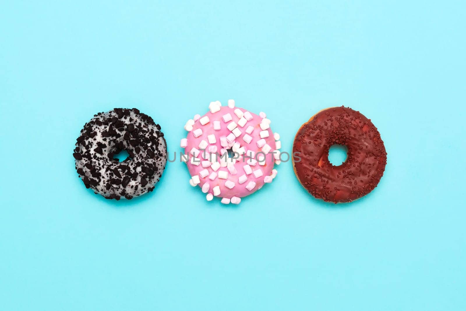 Delicious donut on color background. Mix of multicolored doughnuts, copy space