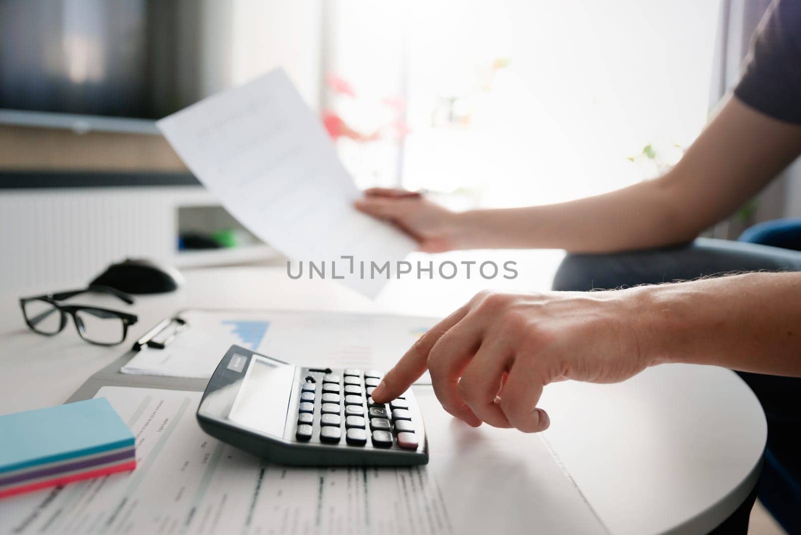 Budget and loan paper in office. Business accounting concept with businessman using calculator.