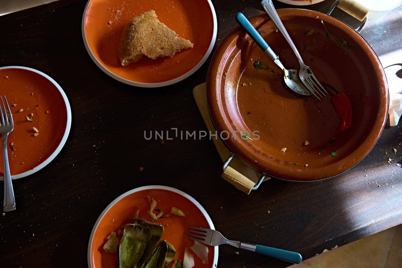 Dirty crockery and dirty clay plates and pots with the rest of unfinished lunch. Food blogging by artgf