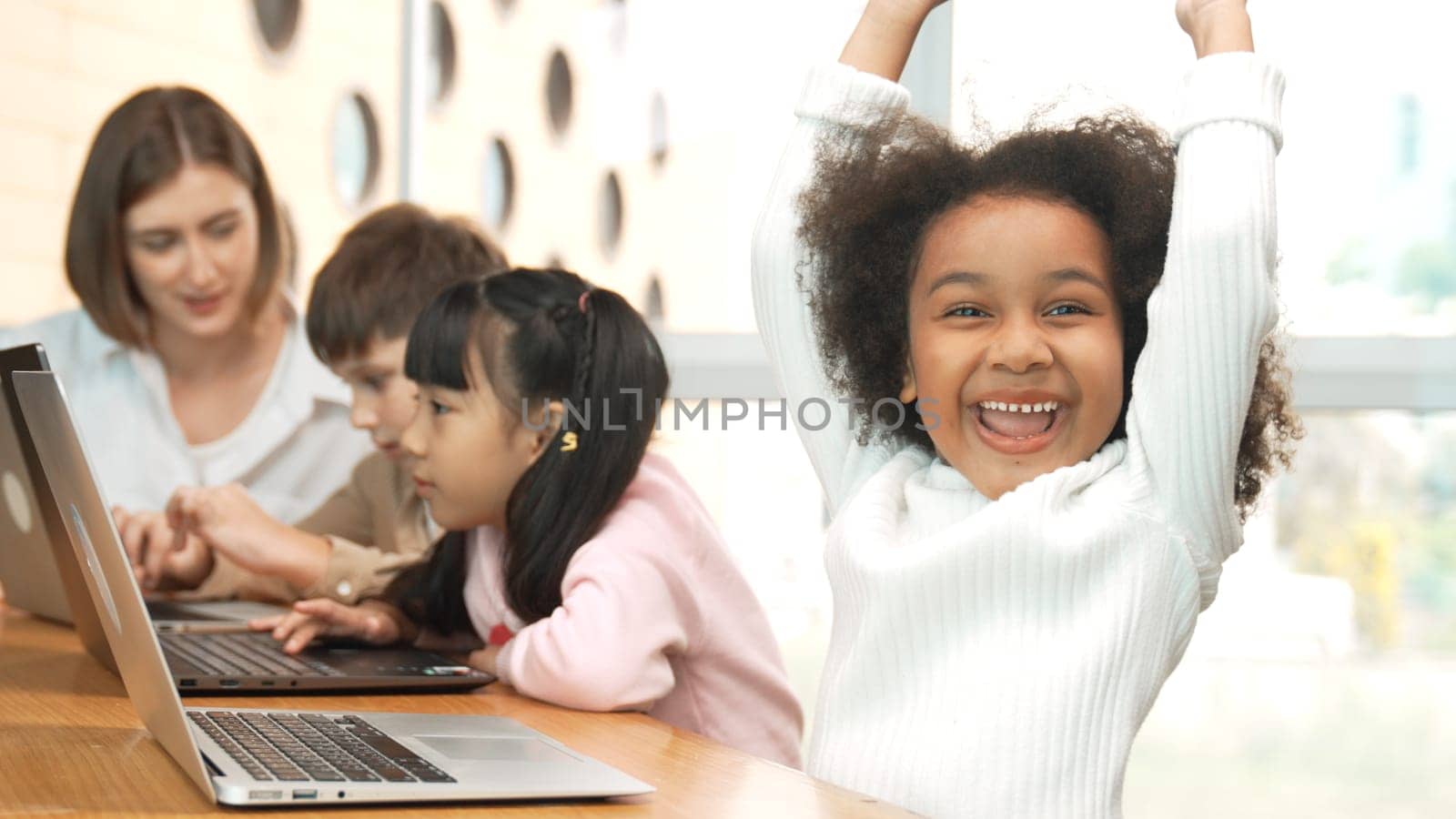 African girl play laptop with diverse friend learning prompt at STEM technology class. Multicultural student study about engineering code and programing system with blurring background. Erudition.