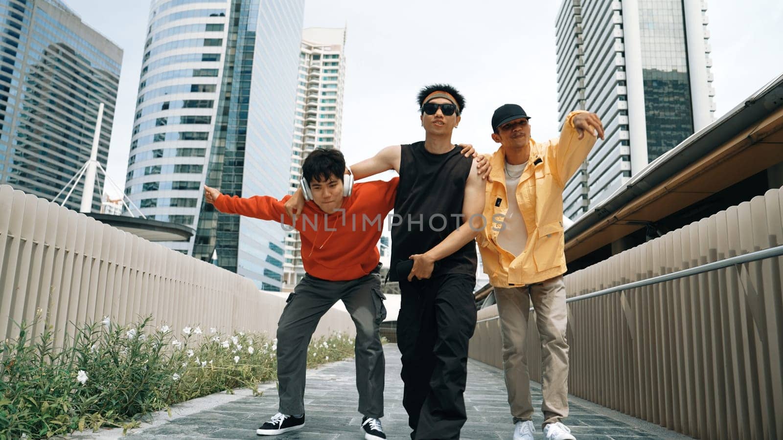 Group of handsome hipster standing while looking at camera with city view. Professional break dancer wear stylish cloth while moving or waving hands to hip hop music. Modern lifestyle. Sprightly.