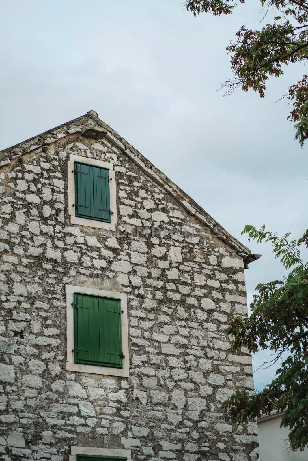 Old stone house and windows with closed green wooden shutters in Old Town, Biograd na Moru of Croatia