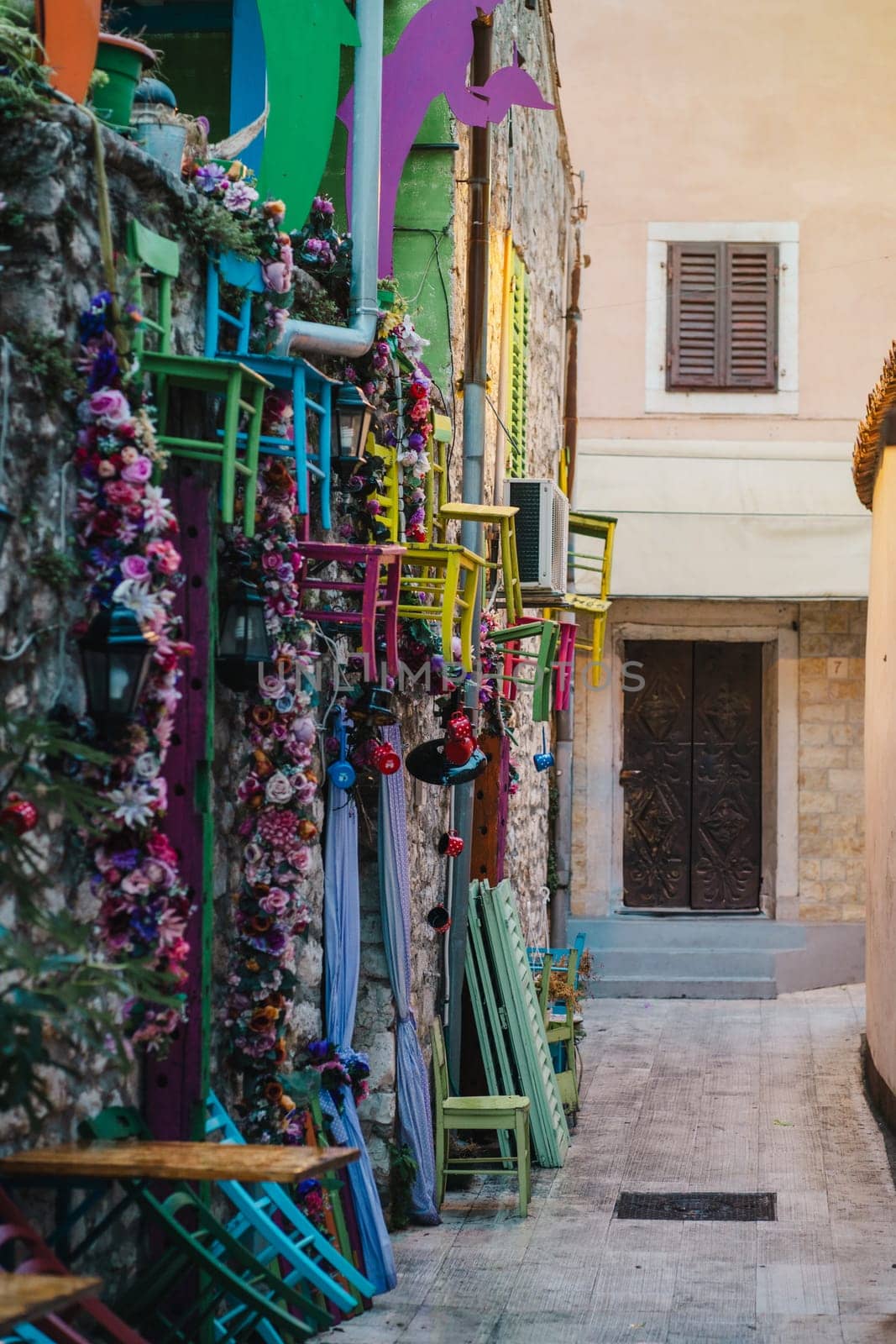 Wooden chairs and traditional decorations on narrow streets of stone Old Town, Biograd na Moru in Croatia