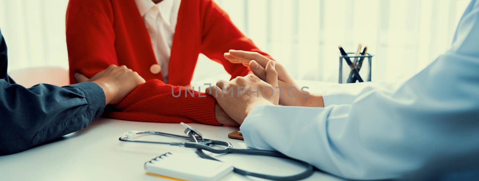 Couple attend fertility or medical consultation with gynecologist at hospital as family planning care for pregnancy while doctor and husband consoling young wife through appointment. Panorama Rigid