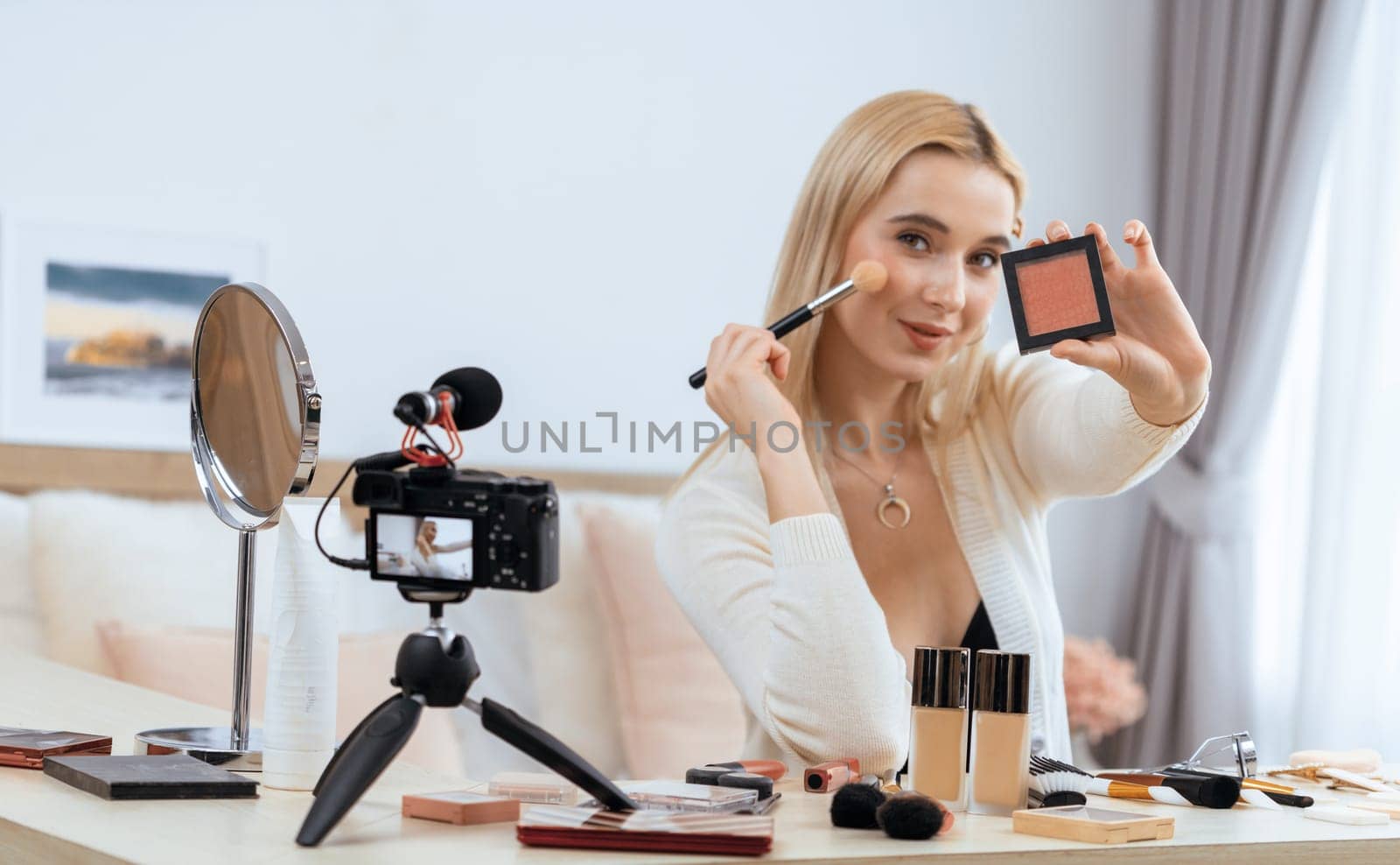 Young woman making beauty and cosmetic tutorial video content for social media. Beauty blogger smiles to camera while showing how to beauty care to audience or followers. Panorama Blithe