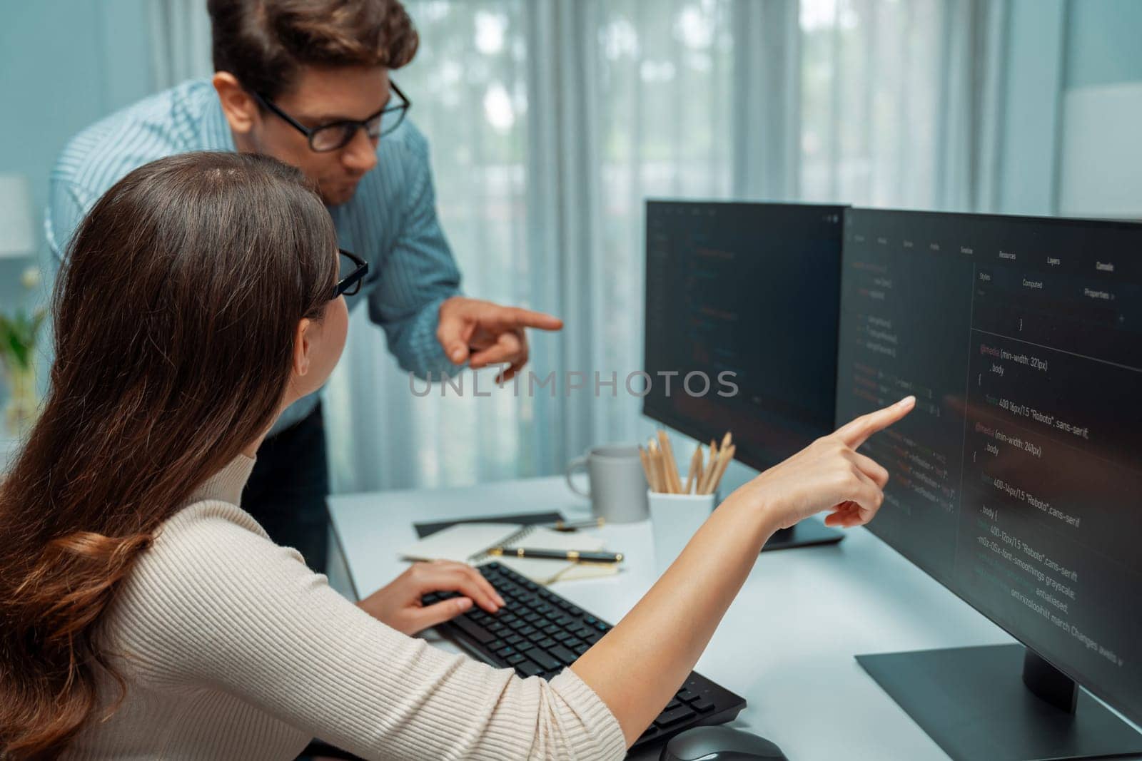 Team skilled developers program thinking newest coding creative website planning software project on two pc screen, comparing with typing full stack data analyzing prompt design at office. Postulate.