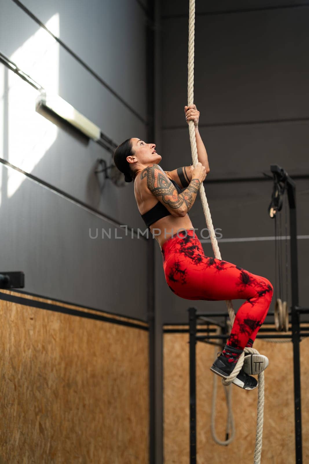 Sportive mature woman exercising with a rope in a gym by javiindy