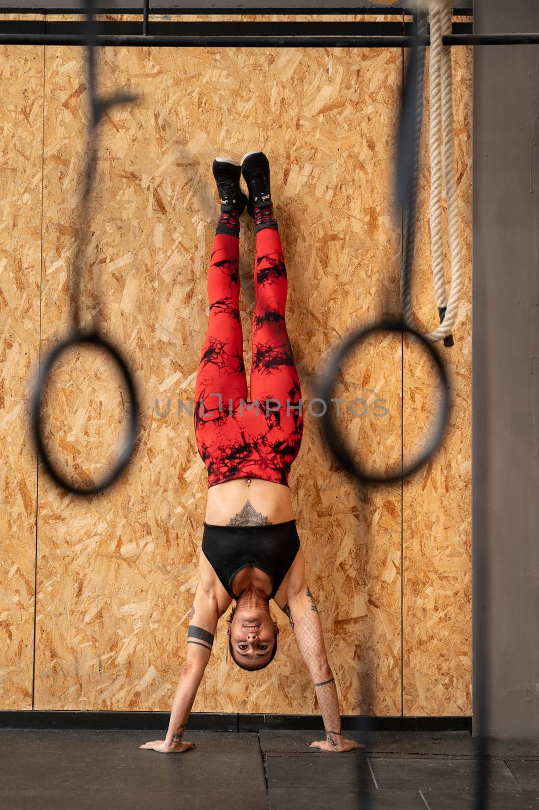 Woman performing handstand exercise in the gym by javiindy