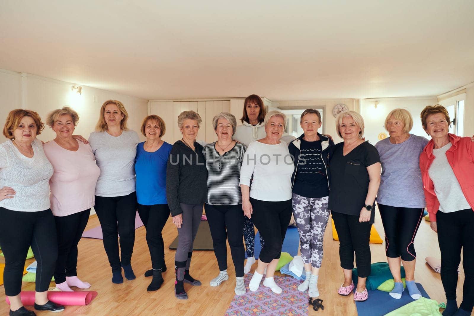 A vibrant community of senior women, guided by their instructor, embraces the enriching journey of yoga, fostering unity, well-being, and a shared commitment to active aging by dotshock