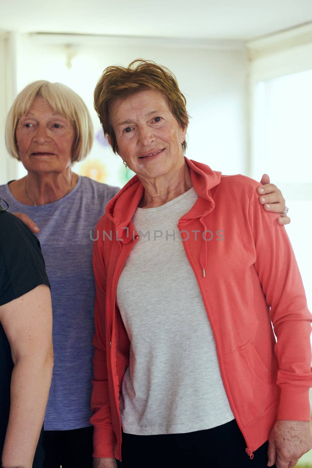 A vibrant community of senior women, guided by their instructor, embraces the enriching journey of yoga, fostering unity, well-being, and a shared commitment to active aging.