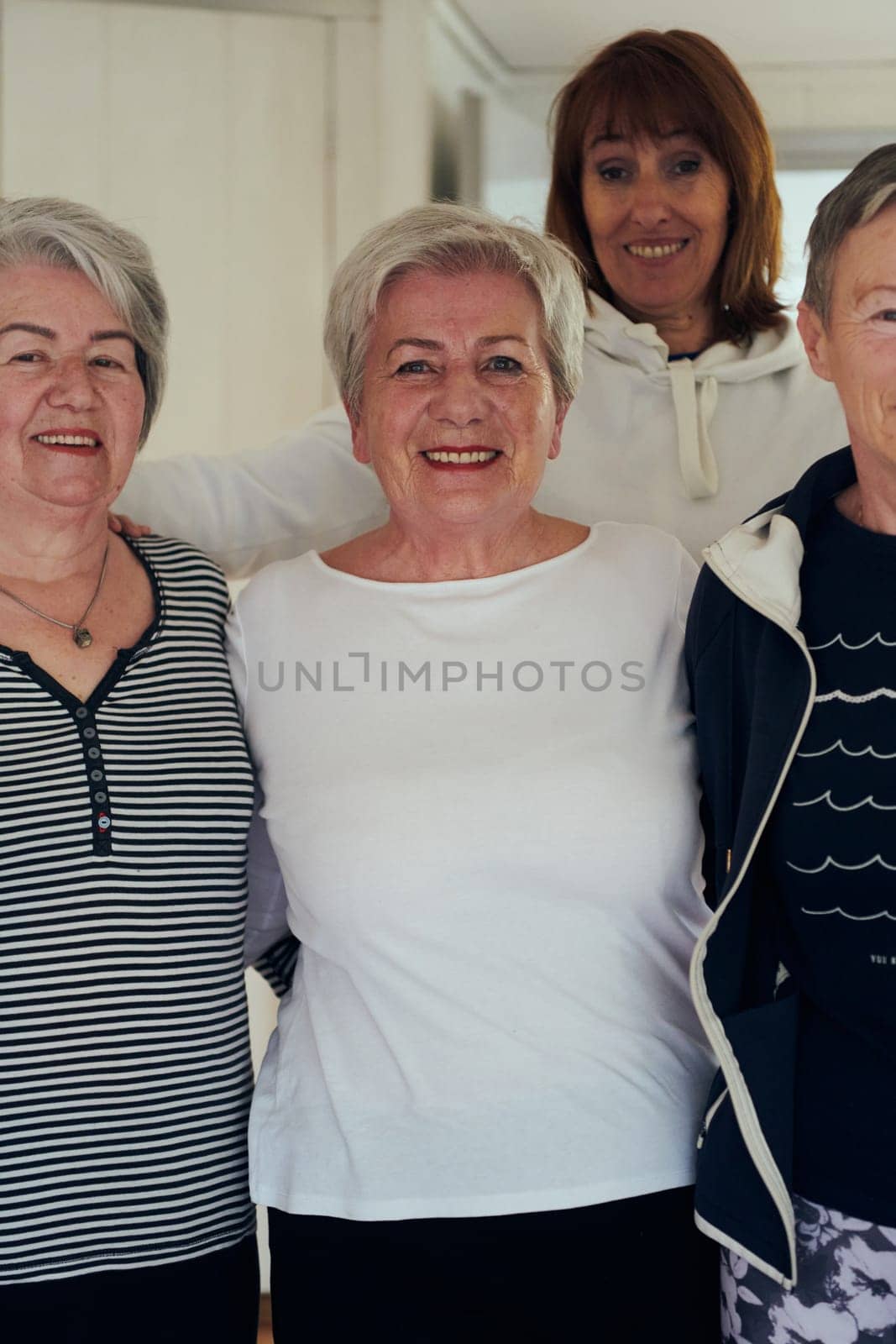 A vibrant community of senior women, guided by their instructor, embraces the enriching journey of yoga, fostering unity, well-being, and a shared commitment to active aging.