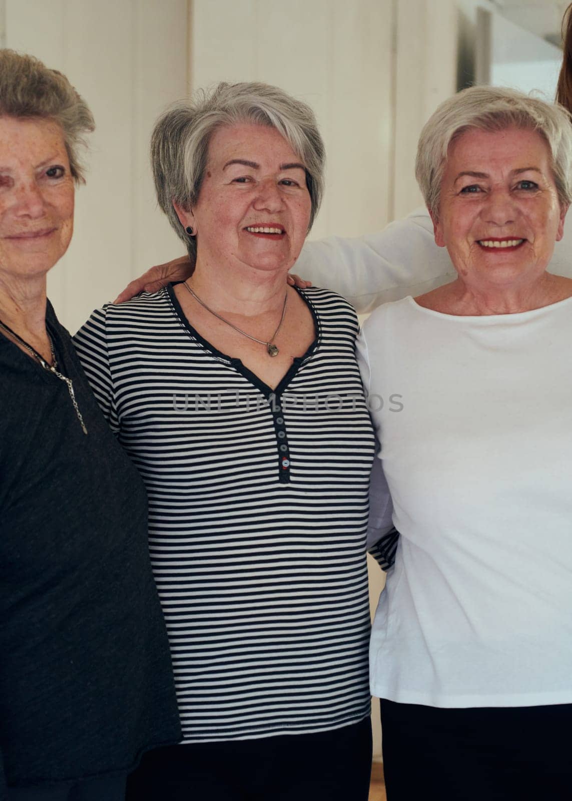 A vibrant community of senior women, guided by their instructor, embraces the enriching journey of yoga, fostering unity, well-being, and a shared commitment to active aging.