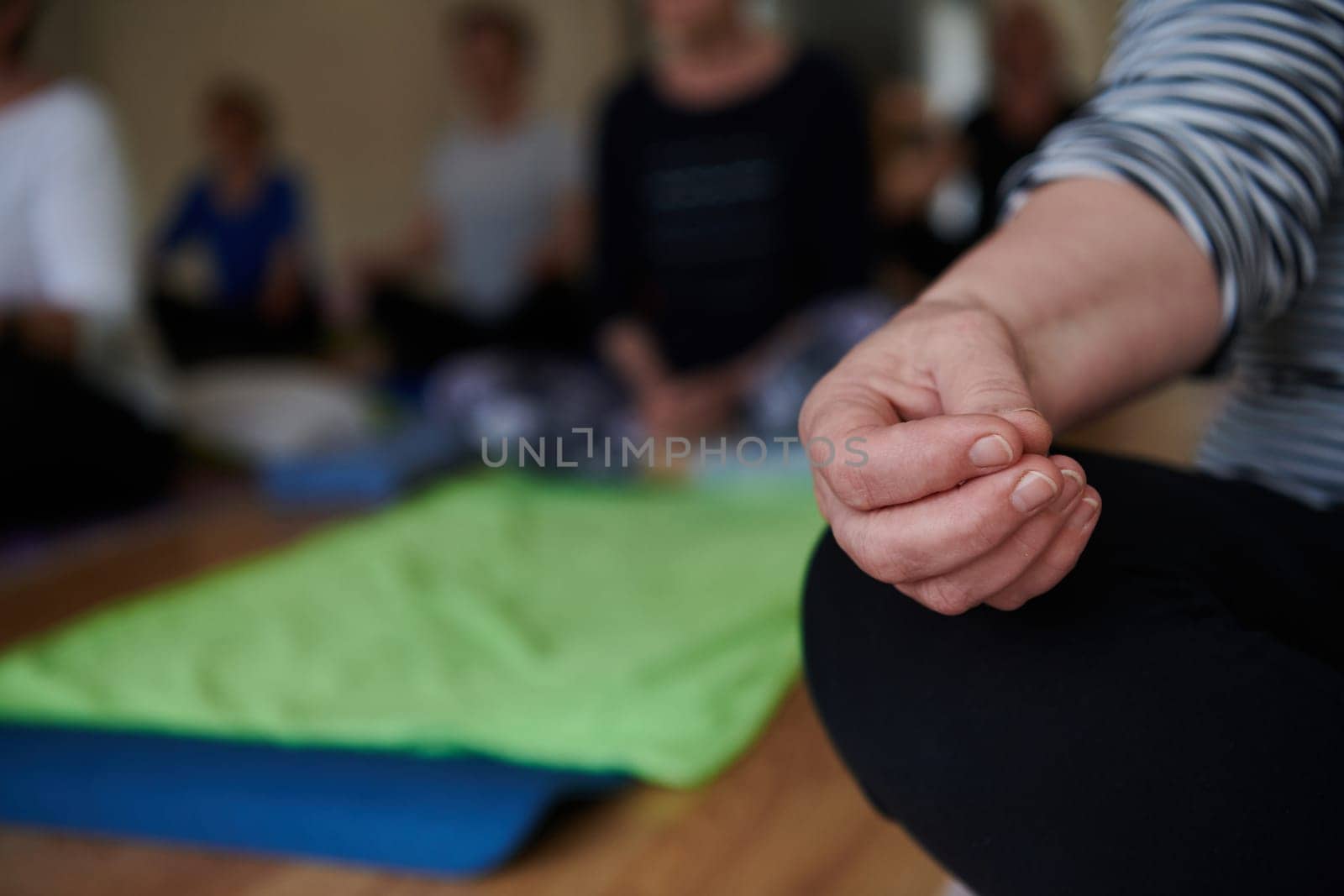 In this sunlit space, a senior woman's hand gracefully engages in various yoga poses, embodying the essence of active aging, health, and inner peace by dotshock