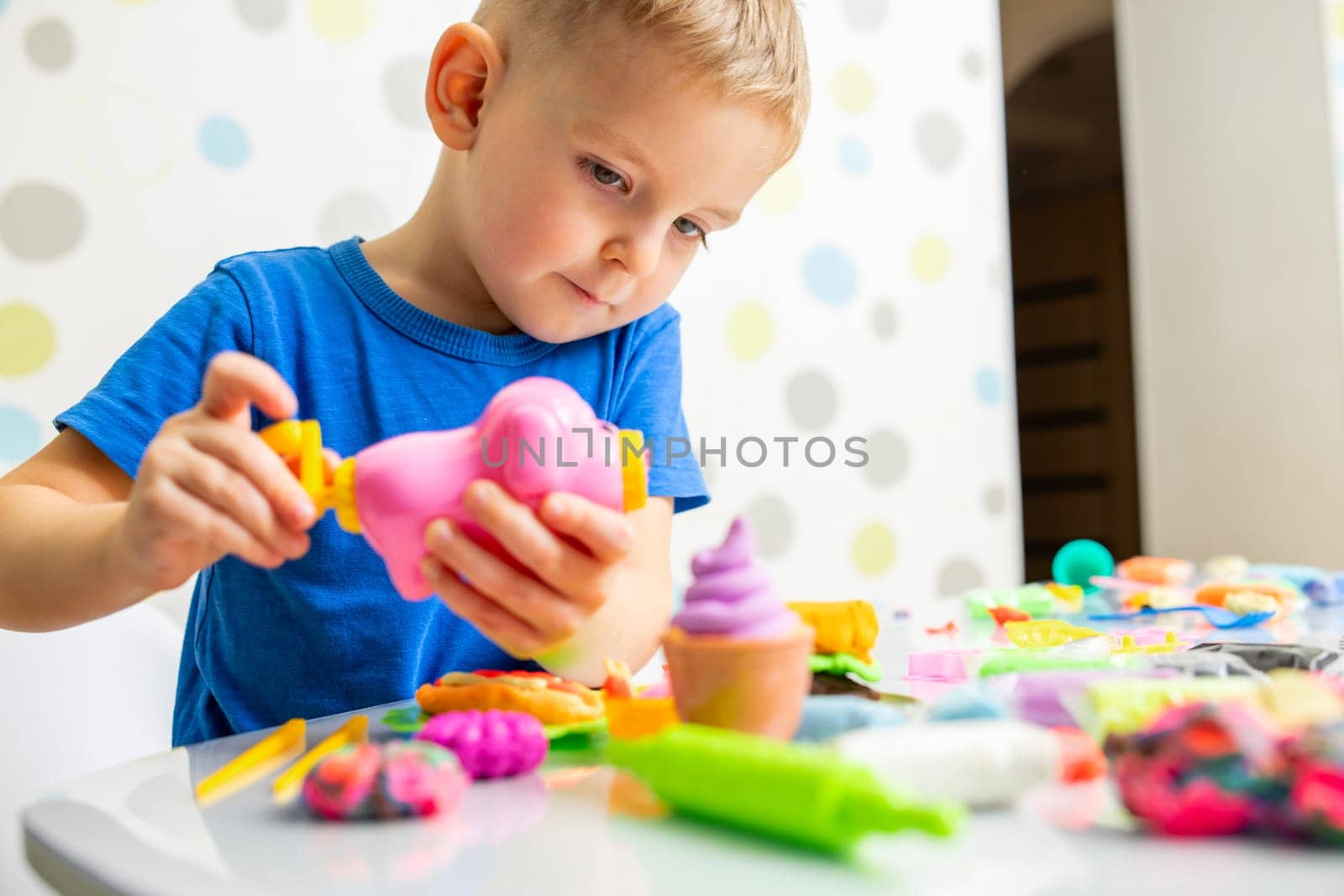Kids playing with play dough. Cute children sitting at the table and plays with playdough. Creative leisure activity concept